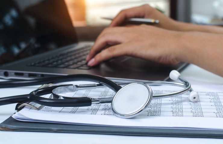 Trends Impacting the Medical Billing & Coding Field - UEI College typing on laptop