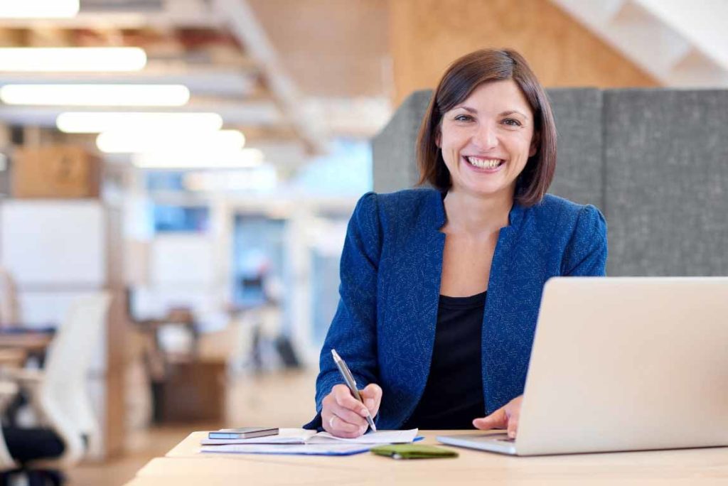 Tips for Turning a Temp Job into a Full Time - UEI Lady working on laptop