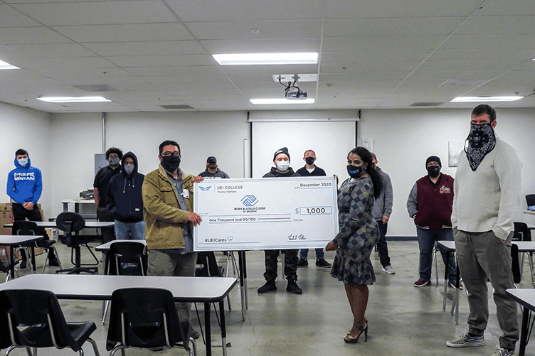 Students in UEI College Fresno Win Contest, Make $1000 Donation to Boys & Girls Club - UEI College Fresno UEI college student holding large check