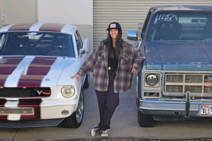 automotive-technician-student-standing-next-to-cars