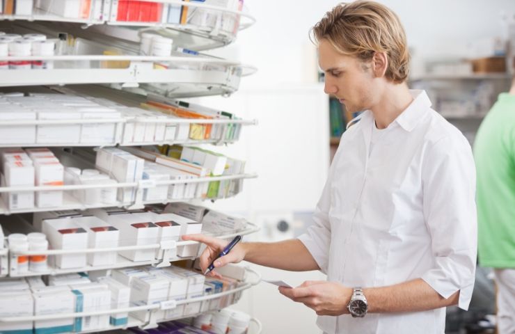 pharmacy technician male in white shirt