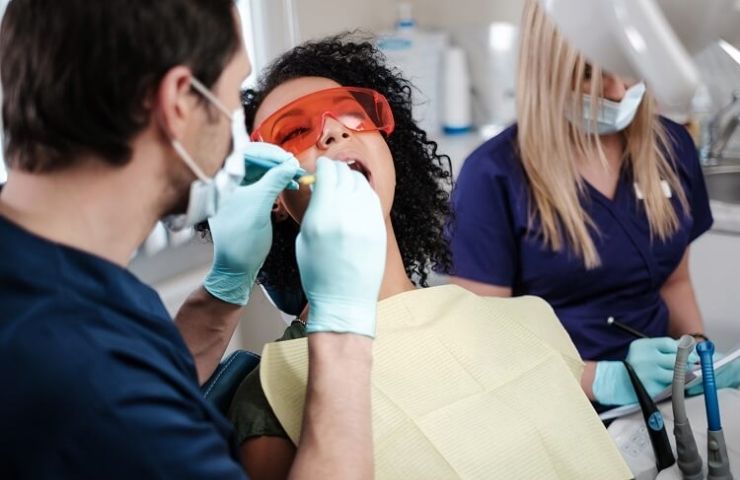 Dental assistant working on patient