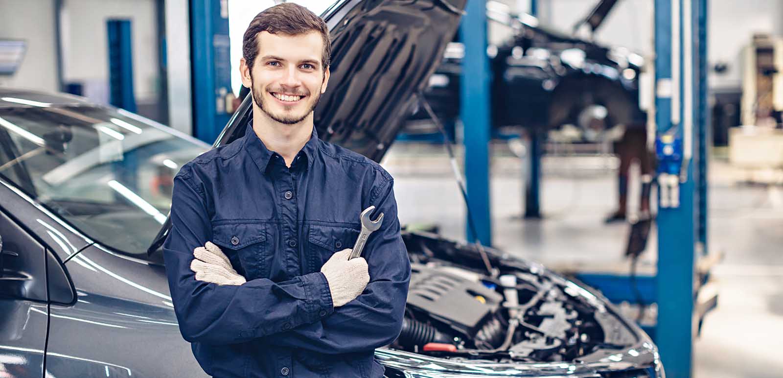 automotive-technician-standing-next-to-car